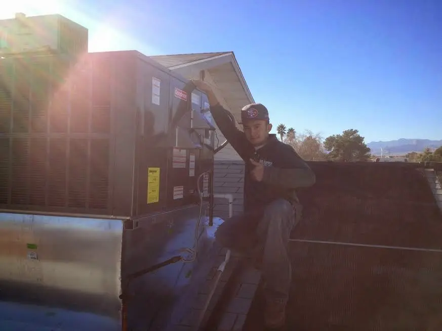 HVAC technician performing Heat Pump Repair on a rooftop unit in Cabot